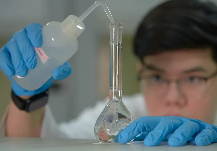 Close view of Dhup working with a flask