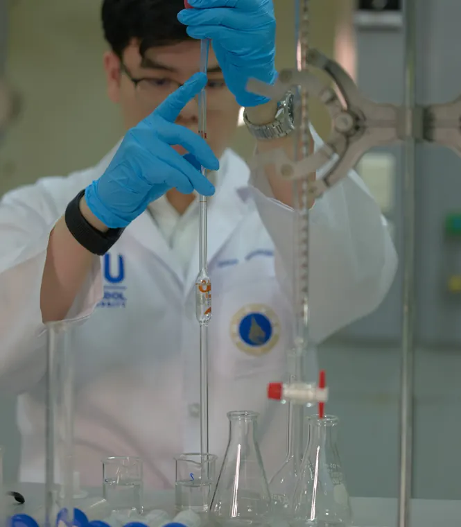 Dhup working with a pipette in the MUIC laboratory